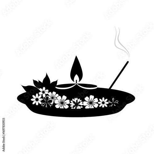 A black silhouette of a spiritual offering tray with a lit diya lamp, flowers, and a burning incense stick.