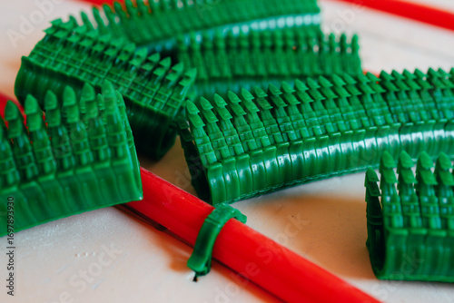 Pipe clamps for underfloor heating installers, fastening plastic pipes, pipe bundle. Installation of technical equipment, concept of parts for plumbing and heating construction