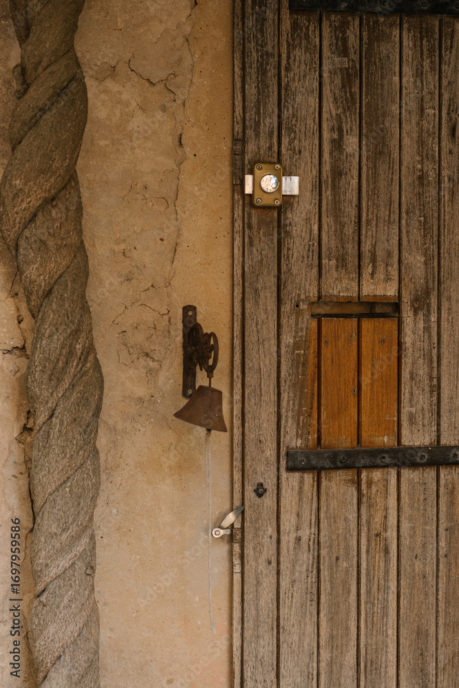Fototapeta premium Rustic wooden door with metal bell and lock
