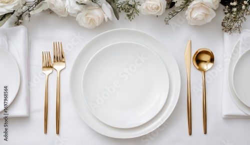 Elegant white table setting with gold flatware