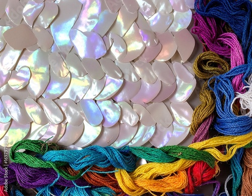 A vibrant assortment of multi-colored threads, featuring shades of red, blue, green, yellow, and purple, neatly arranged in a creative display.