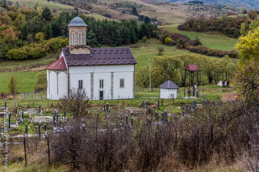 Obraz premium Cemetery and St. George's church in Donje Lopize village near Sjenica, Serbia