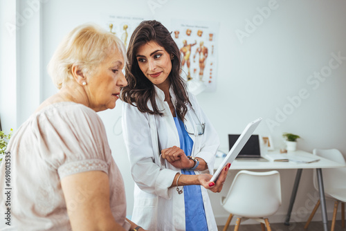 Fototapete Female Doctor Discussing Health Results With Elderly Woman in a Clinic Setting