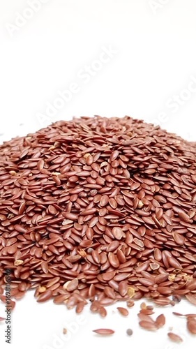 Pile of organic Flaxseeds rotating on a white background, Dry Linum usitatissimum, vertical clip