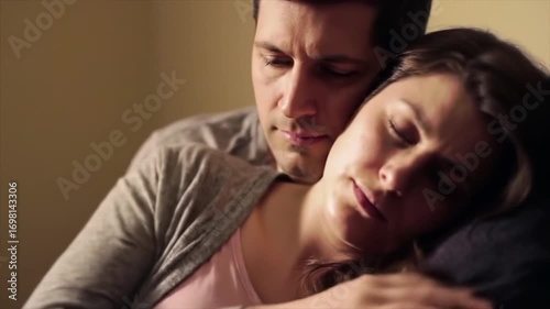 Supportive husband comforting his tired and emotional pregnant wife at home.