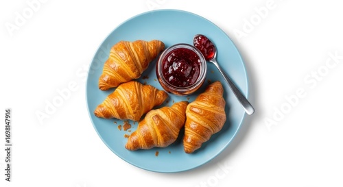 Golden, flaky croissants served with sweet berry jam on a blue plate, perfect for a delicious breakfast or snack. Isolated on white.