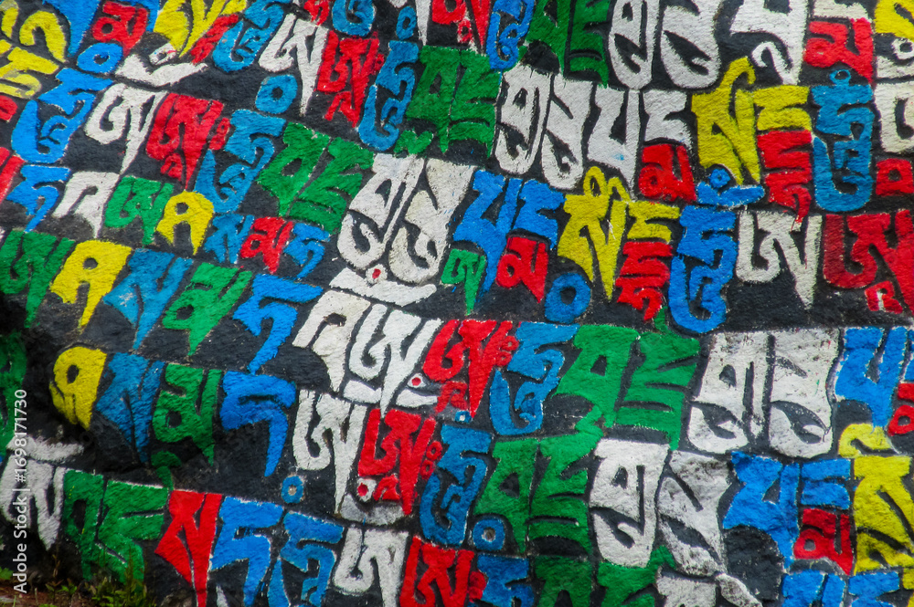Fototapeta premium Namche Bazar, Nepal. Mani stones sacred religious symbols carved on the rocks along the mountain path on Everest Base cap trekking. Hiking in Himalaya mountains. Traditional culture symbol of Nepal