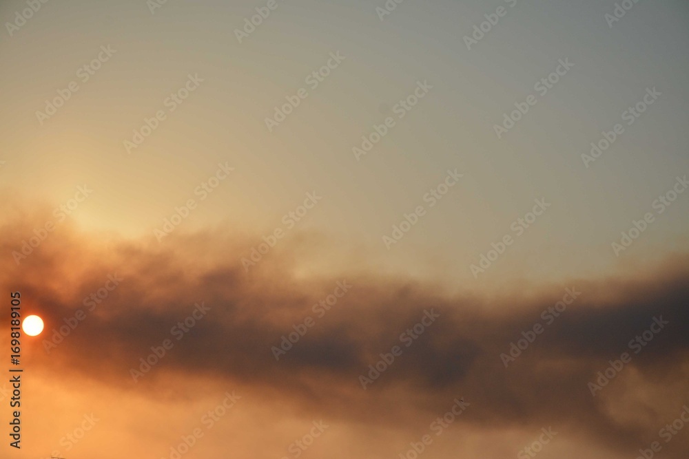Fototapeta premium Smoke obscures the sky, the sun peeks out from behind the smoke screen