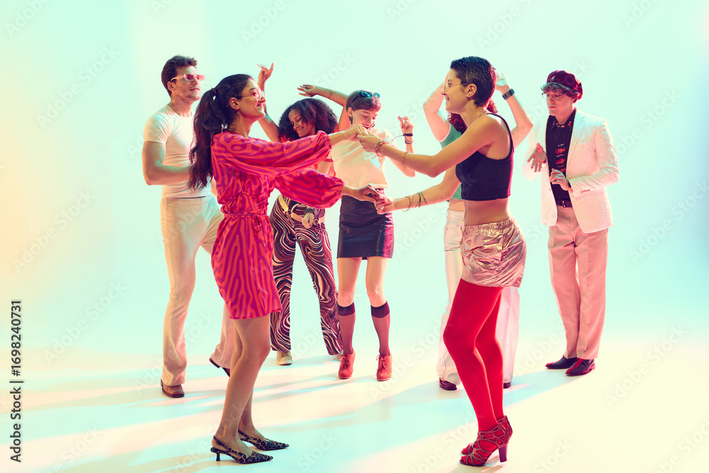 Fototapeta premium Stylish friends dancing together in retro themed group celebration. Concept of dance parties, youth culture, nightlife entertainment and lifestyle fun.