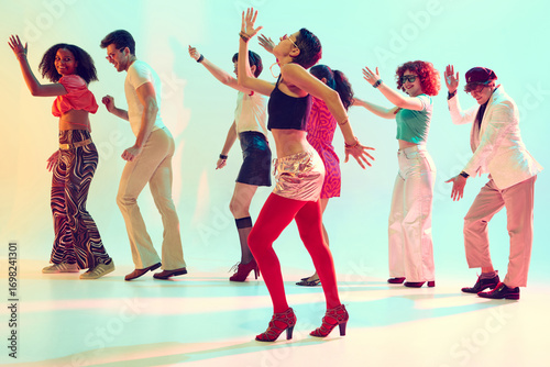 Vászonkép Retro styled group dancing with joyful energy under colorful lights