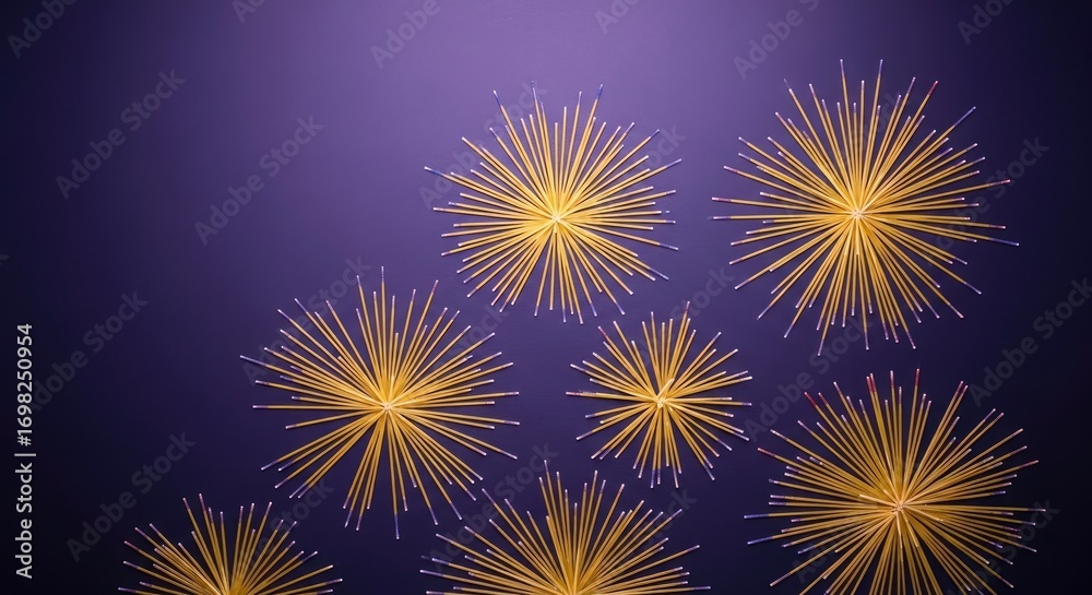 Fototapeta premium Golden spaghetti noodles arranged in radiating starburst patterns on a dark purple background, creating an abstract and artistic culinary composition.