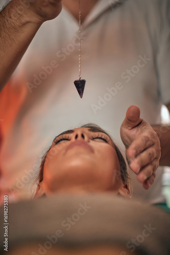 Beautiful woman recieving a reiki treatment in a health clinic. Plumb line, bob.