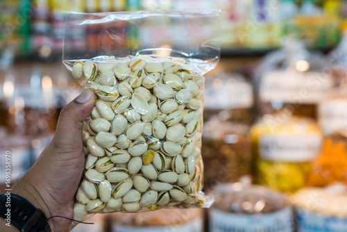 Organic pistachios with their shells still intact in vacuum sealed bag on hand