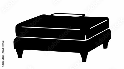 Illustration of a black ottoman with a small cushion on top and four legs on a white background silhouette