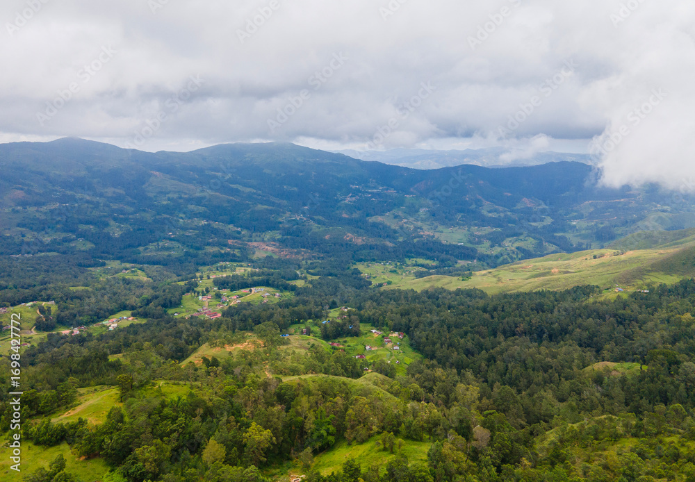 Obraz premium The spectacular green hills and mountain landscapes of Flesha area, a popular tourist destination in Ainaro, Timor-Leste, seen from above. A dramatic aerial journey over a remote and verdant region