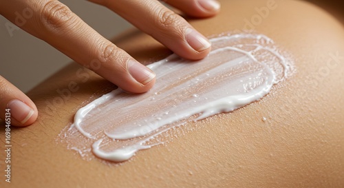 Hand spreading white cream on skin fingers applying lotion evenly