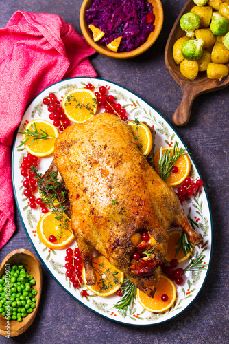 Roasted whole duck with fuits and berries served on oval side dish plate. High angle view