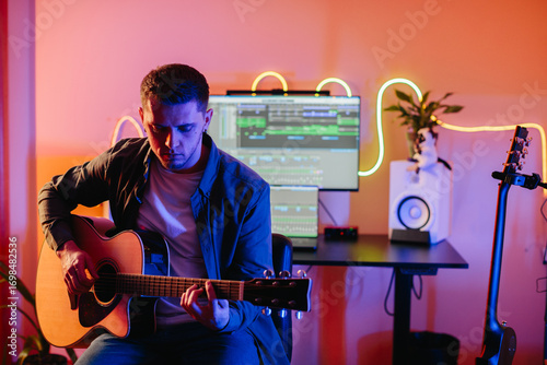 Papier peint Musician composing new song playing acoustic guitar and using music production s