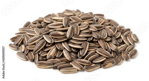 Close-up of a heap of unpeeled, striped sunflower seeds, a healthy snack and ingredient, isolated on white.