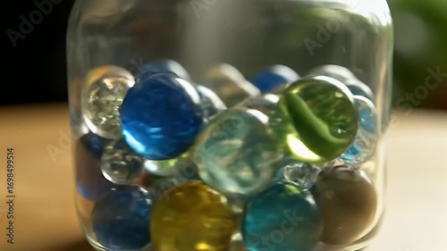 Vibrant Glass Marbles Rolling and Shifting in a Clear Jar, Capturing Light and Reflections