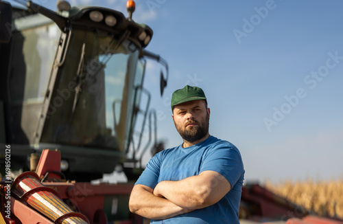Farmer stands next to the harvester
