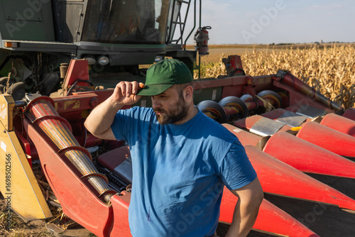 Farmer stands next to the harvester