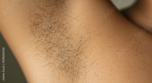 Close-up human armpit featuring dark hair growth showcasing body hair and skin texture
