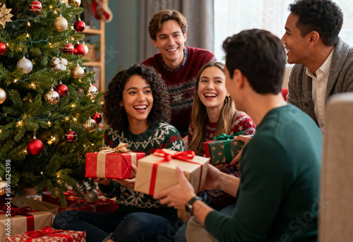 Young friends exchanging gifts at home during Christmas celebration by decorated tree, smiling and enjoying holiday together in cozy living room with winter festive atmosphere