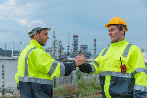 Collaboration between two construction workers in safety gear, shaking hands at industrial site. scene conveys teamwork and professionalism in vibrant, dynamic environment