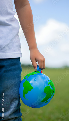 Closeup of a childs hand holding a small globe, symbolizing environmental awareness and care