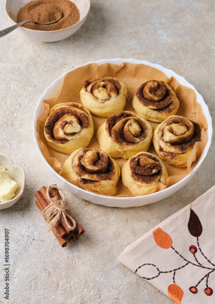 Fototapeta premium Step by step preparation of pumpkin buns on a light concrete background. Formed pumpkin cinnabons in a ceramic mold before baking.