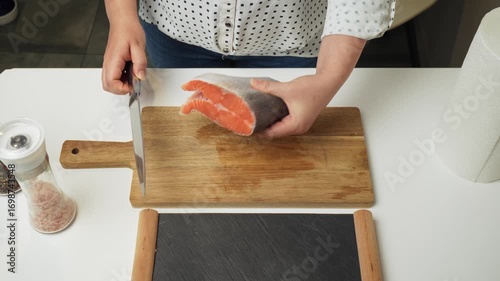 Female hands preparing the trout fish for cooking at home kitchen. Concepts of healthy eating and seafood