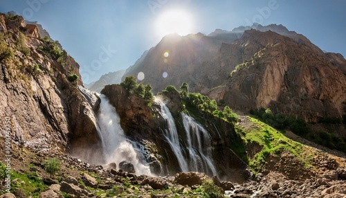 dramatic waterfall cascades down rocky mountain side in tajikistan
