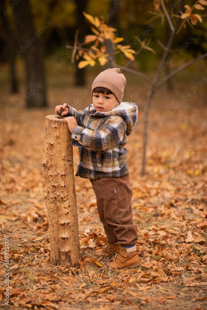 Naklejka premium Happy child standing in an autumn park. autumn concept, autumn mood