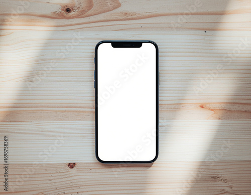 Smartphone Lying on Wooden Table with Blank White Screen – Top View Mockup