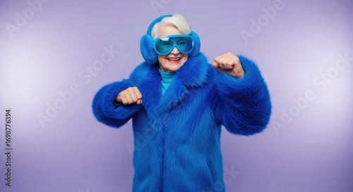 Elderly caucasian female in blue fur coat dancing with oversized accessories