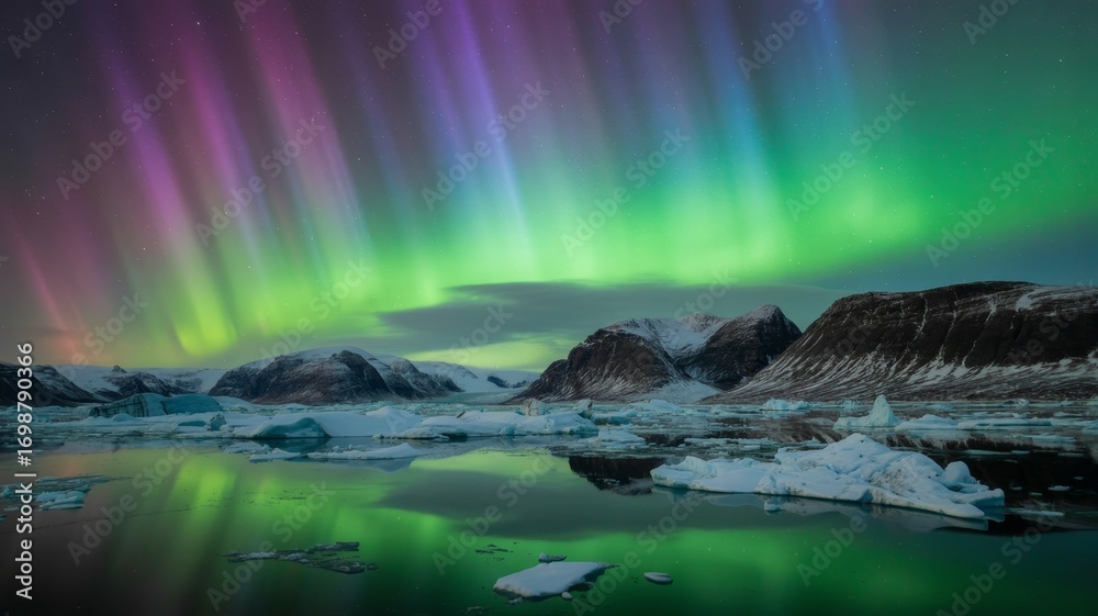 Naklejka premium Spectacular aurora borealis over snowy mountains and icy waters in iceland