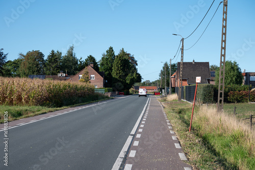 Asphalt road with cycling lane through the countryside in Belsele, East Flanders, Belgium