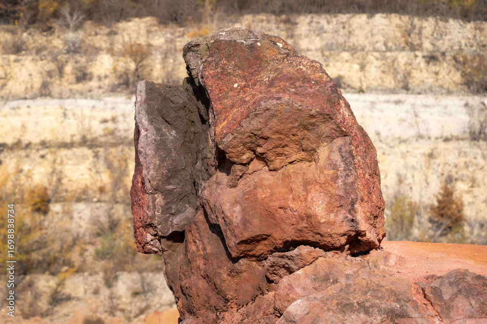 Obraz premium Eroded bauxite rock formation with bright orange colors in an abandoned bauxite mine