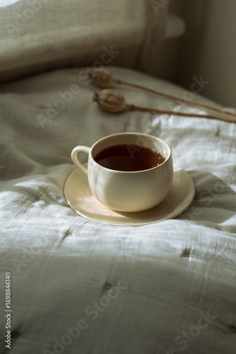 coffee or tea in bed with beautiful warm light. Minimal aesthetic still life composition with copy space	