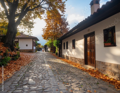 Charming Cobblestone Street with Autumn Leaves and Cozy Houses