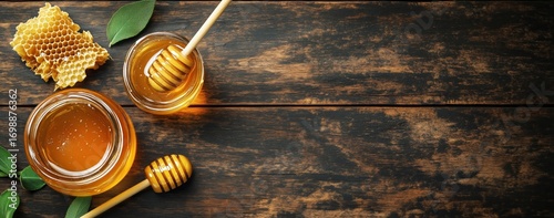 Golden Honey in Jars, Honeycombs, and Dipper Lie on a Dark Wooden Table.