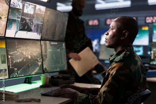 Foto Counterterrorism division operative wearing camouflage uniform using target acquisition tech to detect enemy location