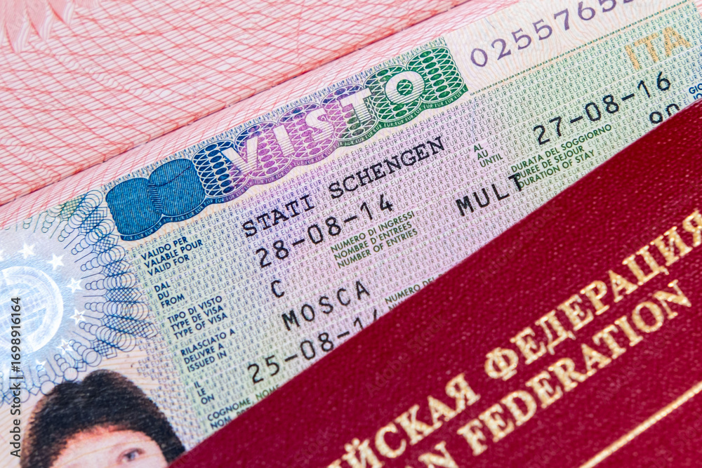 Obraz premium Schengen visa allows multiple entry to European Union, red Russian Federation passport in focus, travel ban restrictions and denied visas for Russian citizens, travel freedom across Europe