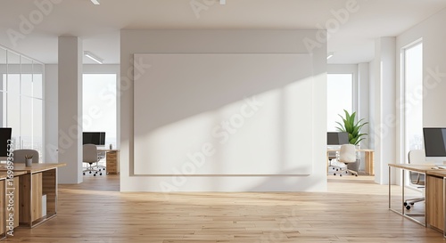 Modern open plan office space with large blank wall, light wooden floors and natural light.
