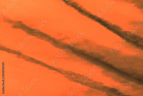 Traces airplane air trail jet line stripe sunset orange sky background