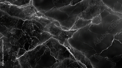 Black marble texture with intricate white veining creates dramatic and elegant background. dark surface evokes sense of depth and sophistication