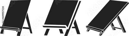 Three black chalkboards on easels in a row against a white background