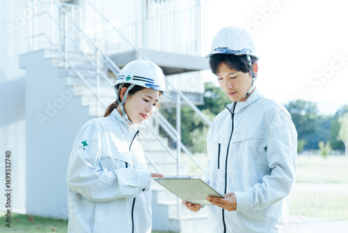 作業着で仕事する男女　打ち合わせ 工事現場
Men and women working in work clothes, meeting, construction site