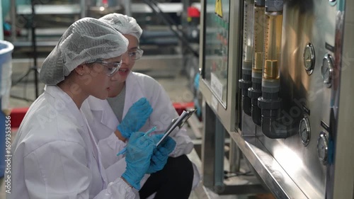 The specialist in drinking water  testing the purification of water in the laboratory  at the water factory. Female worker inspecting water bottle on production line in spring water factory.